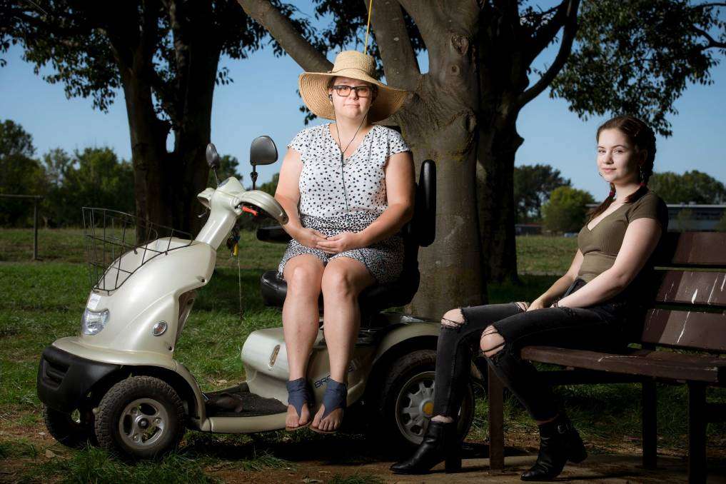 Two women outdoors in Canberra, one using a mobility scooter, living with chronic fatigue